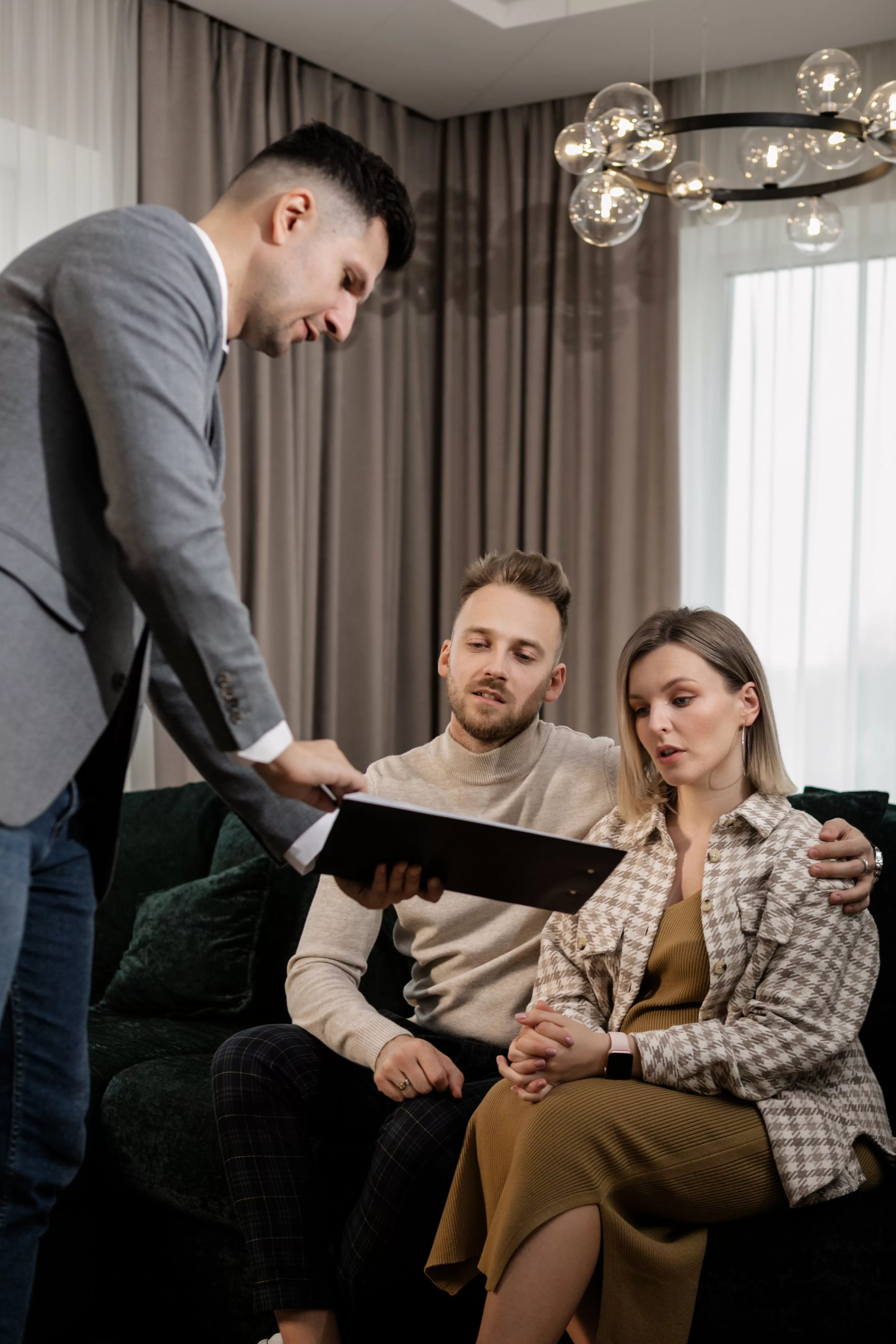 Expert shows documents to a couple who is sitting on a sofa